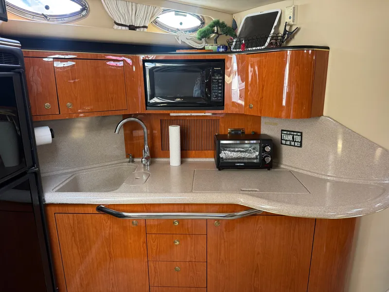 Slide: The Image of The galley of a 2001 Sea Ray 380 Sundancer with wood cabinets, sink, microwave, and toaster. - 35