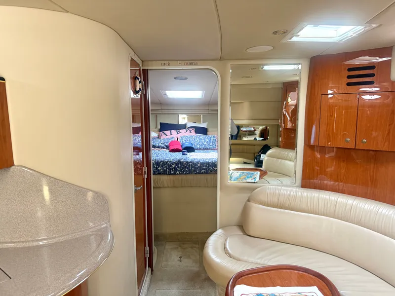 Slide: The Image of Interior of the 2001 Sea Ray 380 Sundancer with curved sofa, bed, and wooden cabinetry. - 43