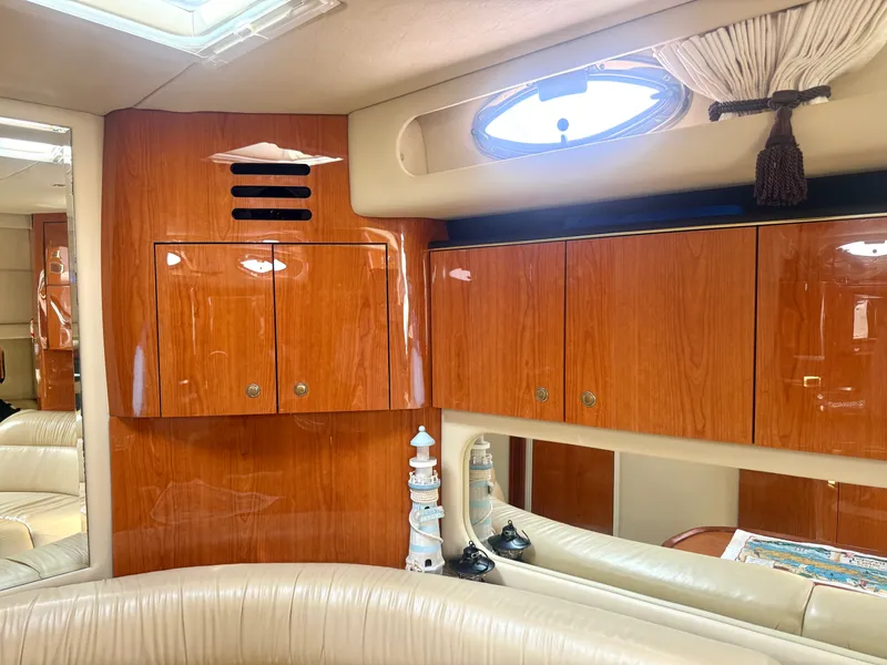 Slide: The Image of Interior of a 2001 Sea Ray 380 Sundancer with glossy wood cabinets and cream-colored upholstery. - 42