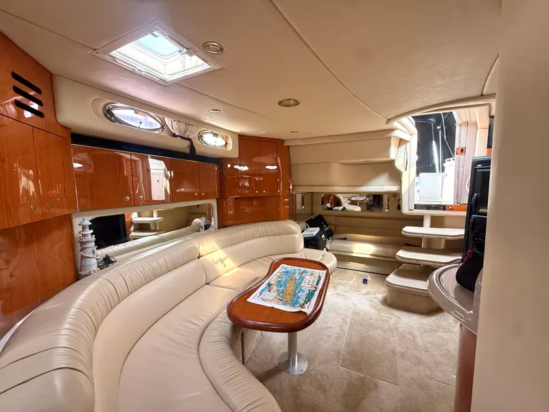 Slide: The Image of Interior of the 2001 Sea Ray 380 Sundancer with curved sofa and wooden table. - 47