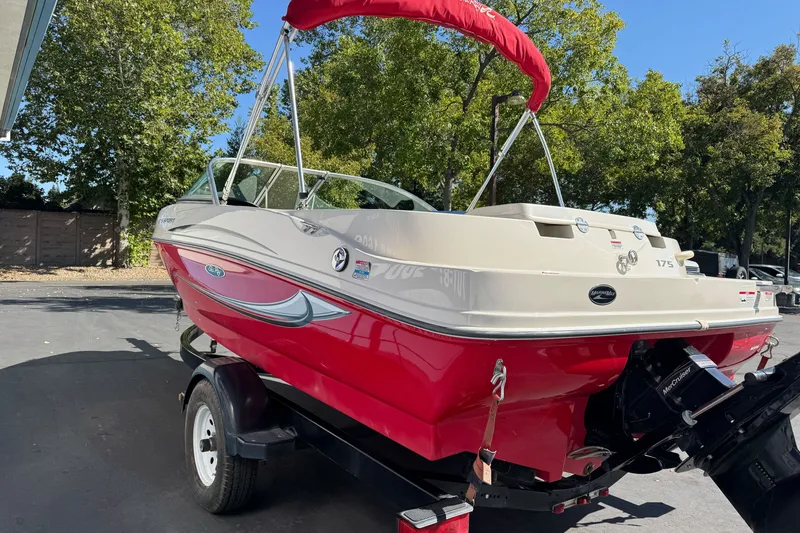 Slide: The Image of 2008 Sea Ray 175 Sport boat with red hull on trailer, parked outdoors. - 24