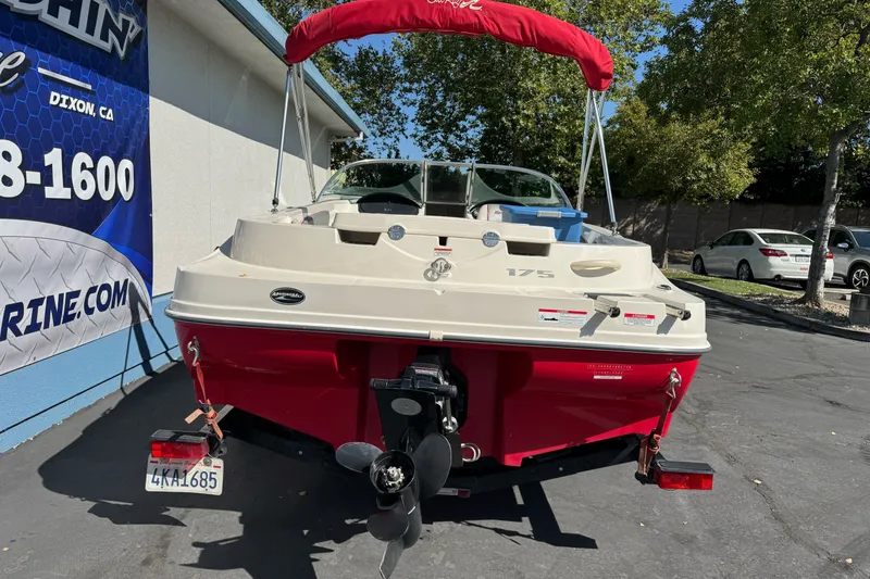 Slide: The Image of 2008 Sea Ray 175 Sport boat with red hull and canopy, parked outdoors. - 23