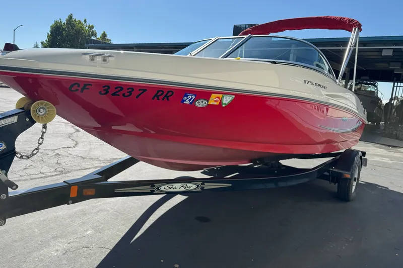 Slide: The Image of 2008 Sea Ray 175 Sport boat with red hull on trailer, parked outdoors. - 6