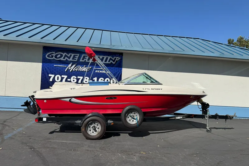 The Image of 2008 Sea Ray 175 Sport boat on trailer, parked outside marine dealership. - 1