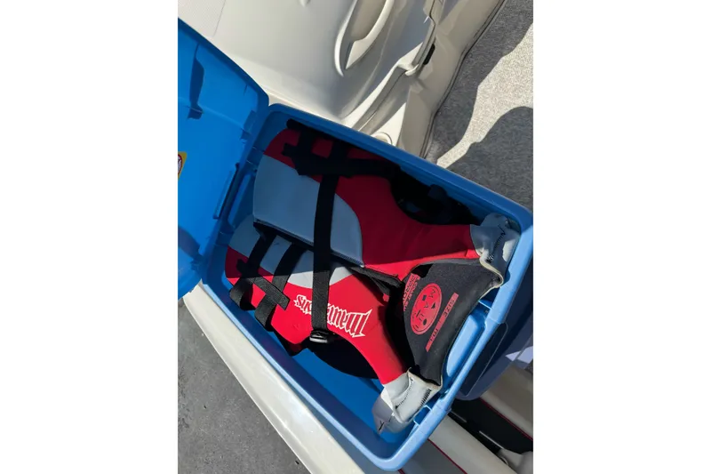 Slide: The Image of Life jackets stored in a blue container on a 2008 Sea Ray 175 Sport boat. - 18