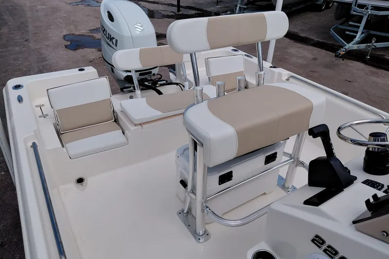 Slide: The Image of 2027 Bulls Bay 2200 XS boat interior with beige seating and Suzuki outboard motor. - 24