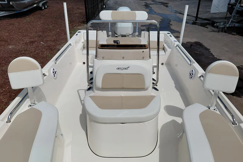 Slide: The Image of 2027 Bulls Bay 2200 XS boat interior with beige seating and steering console. - 15