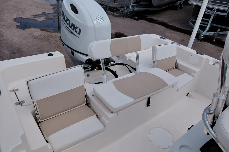 Slide: The Image of 2027 Bulls Bay 2200 XS boat interior with Suzuki outboard motor and beige seating. - 28