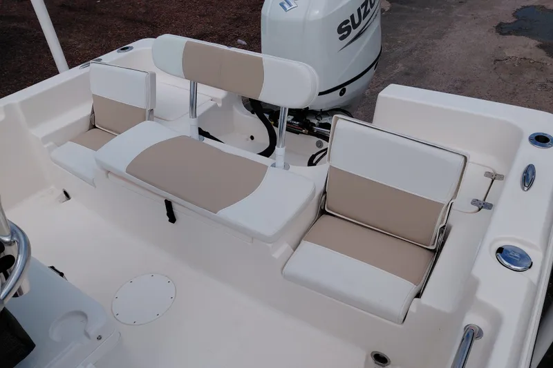 Slide: The Image of 2027 Bulls Bay 2200 XS boat interior with beige and white seating, Suzuki engine visible. - 27