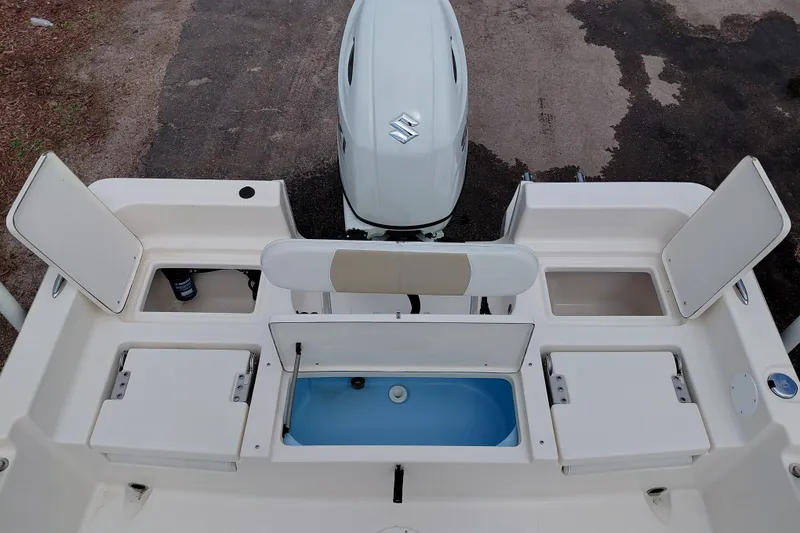 Slide: The Image of 2027 Bulls Bay 2200 XS boat stern view with open storage compartments and Suzuki outboard motor. - 29