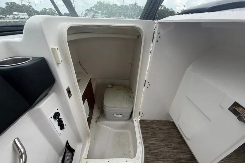 Slide: The Image of Interior of a 2018 Scarab 255 ID boat featuring a compact marine toilet. - 33