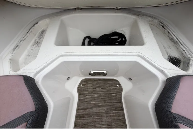 Slide: The Image of The image shows the storage area of a 2018 Scarab 255 ID boat with rope and cushions. - 45