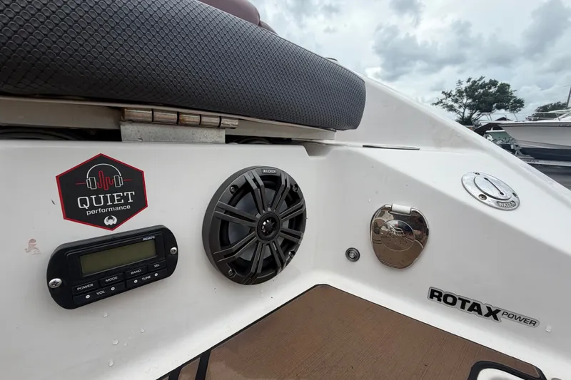 Slide: The Image of 2018 Scarab 255 ID boat interior with audio system and Rotax power emblem. - 77