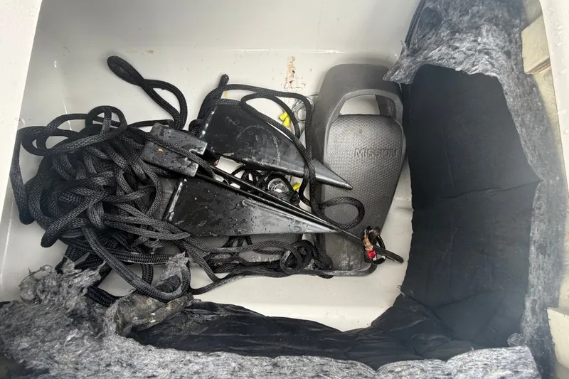 Slide: The Image of Boat storage compartment with ropes, anchor, and equipment in a 2018 Scarab 255 ID. - 18