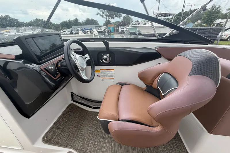 Slide: The Image of Interior of a 2018 Scarab 255 ID boat featuring a modern steering console and comfortable seating. - 24