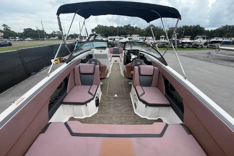 Slide: The Image of 2018 Scarab 255 ID boat interior with seating and canopy, parked in a marina. - 14