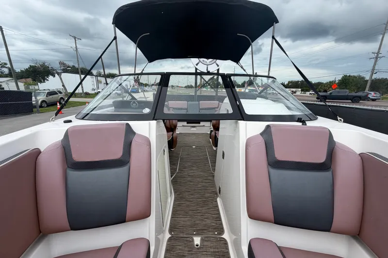 Slide: The Image of 2018 Scarab 255 ID boat interior with dual seating and canopy under cloudy skies. - 52