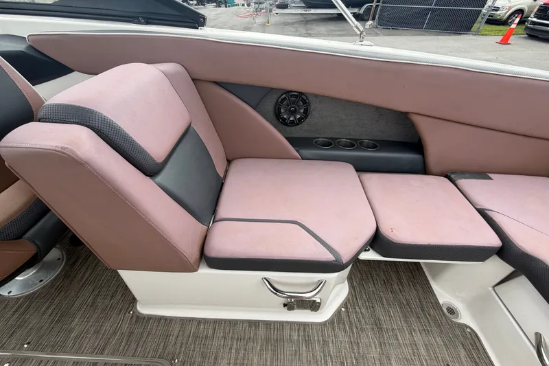 Slide: The Image of 2018 Scarab 255 ID boat interior with pink and black seating, cup holders, and speaker. - 17