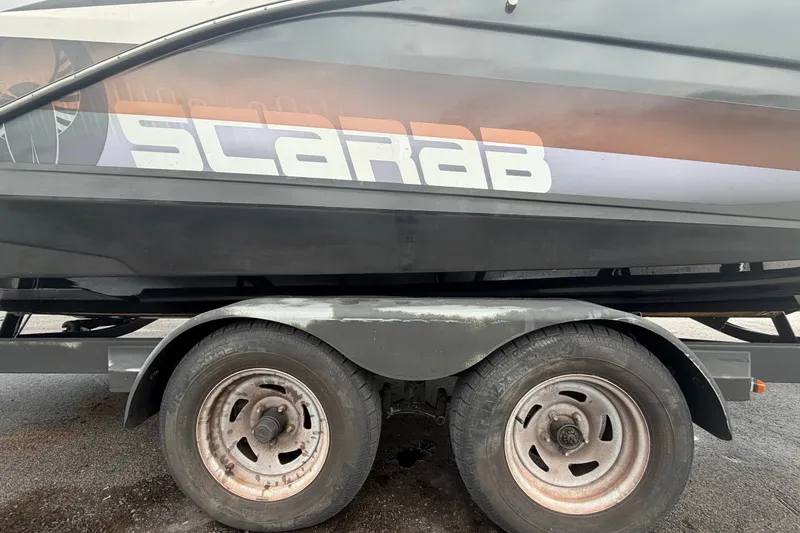 Slide: The Image of 2018 Scarab 255 ID boat on trailer, showcasing brand logo and design. - 82