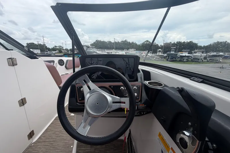 Slide: The Image of Steering wheel and dashboard of 2018 Scarab 255 ID boat, featuring modern controls and display. - 25