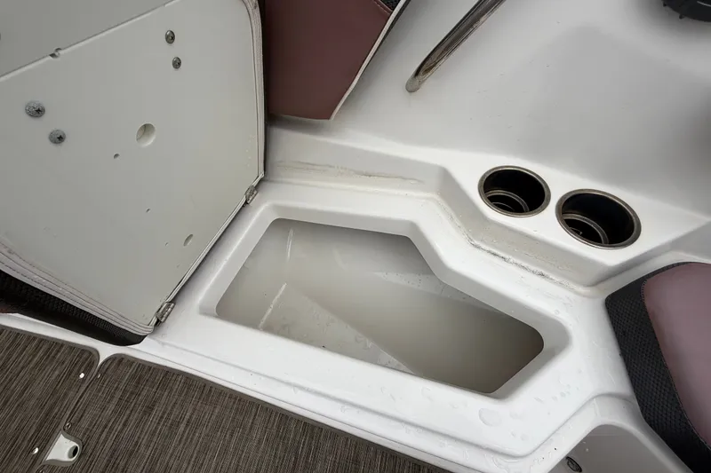 Slide: The Image of 2018 Scarab 255 ID boat storage compartment with cup holders and open hatch. - 43