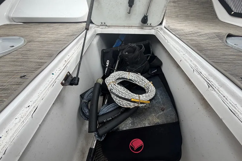 Slide: The Image of Storage compartment in a 2018 Scarab 255 ID boat with rope and equipment. - 22