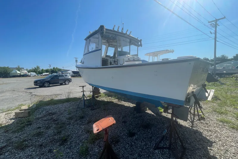 Slide: The Image of 1996 Outlaw Marine 25' OUTLAW boat on stands in a sunny outdoor setting. - 2