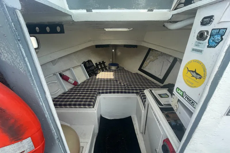 Slide: The Image of Interior cabin of a 1996 Outlaw Marine 25' OUTLAW boat with checkered bedding. - 13