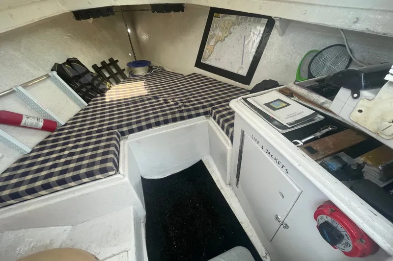 Slide: The Image of Interior of a 1996 Outlaw Marine 25' OUTLAW boat with checkered bedding and navigation tools. - 12