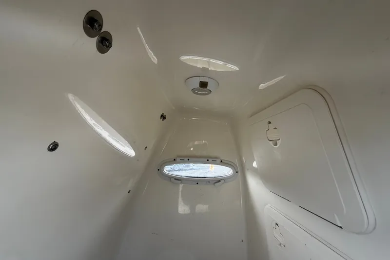 Slide: The Image of Interior cabin of 2021 Pioneer 222 Islander boat, featuring white fiberglass finish. - 33