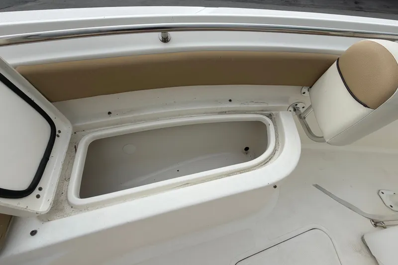 Slide: The Image of Open storage compartment on 2021 Pioneer 222 Islander boat, featuring beige seating and white interior. - 46