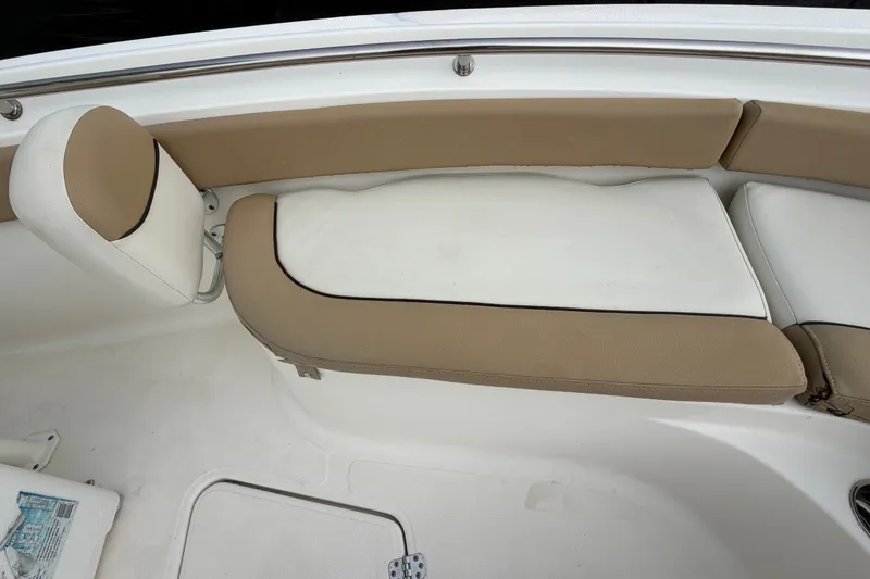 Slide: The Image of 2021 Pioneer 222 Islander boat interior with beige and white cushioned seating. - 40