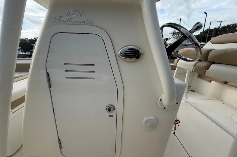 Slide: The Image of 2021 Pioneer 222 Islander boat console with steering wheel and seating area. - 31