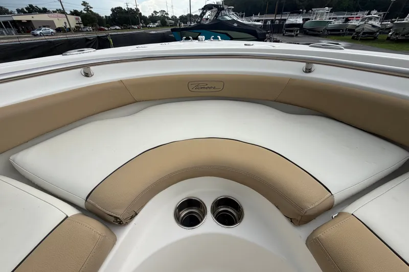 Slide: The Image of Interior view of a 2021 Pioneer 222 Islander boat with beige and white seating. - 42