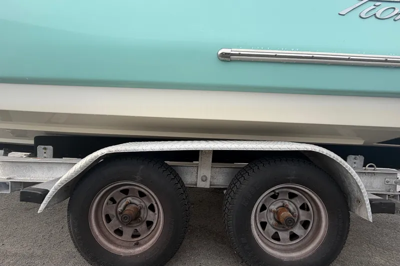 Slide: The Image of 2021 Pioneer 222 Islander boat on trailer, showcasing side view and wheels. - 70