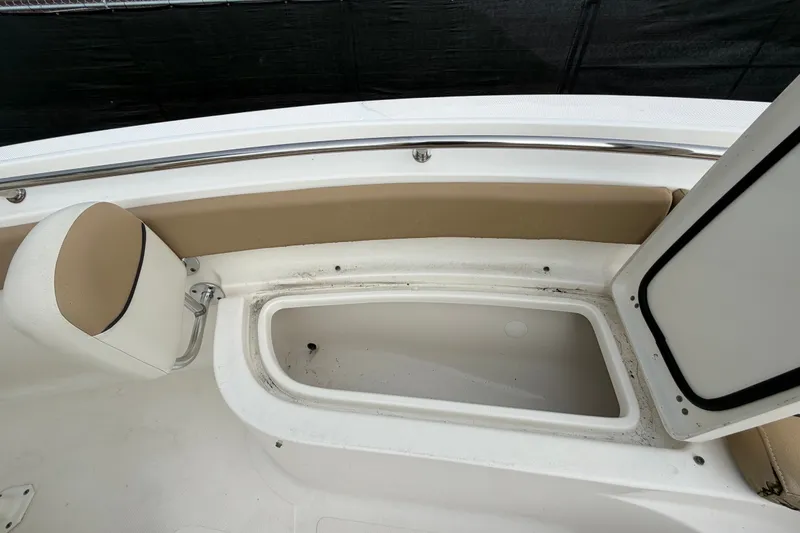 Slide: The Image of 2021 Pioneer 222 Islander boat interior with open storage compartment and cushioned seating. - 41
