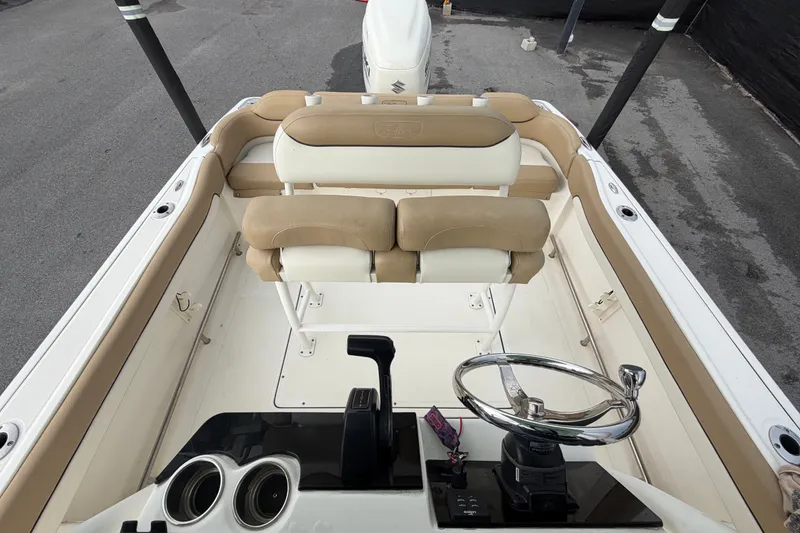 Slide: The Image of 2021 Pioneer 222 Islander boat interior with beige seating and steering console. - 52