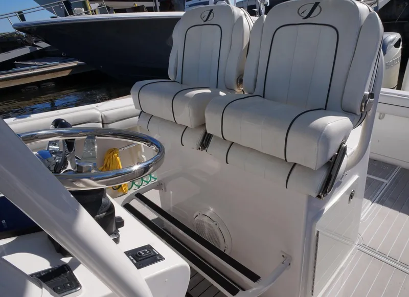 Slide: The Image of 2015 Jupiter 30 FS boat interior with dual white captain's chairs and steering wheel. - 15