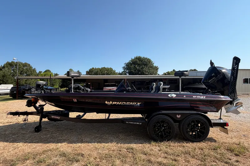 Slide: The Image of 2026 Phoenix 921 Elite X II bass boat on trailer, parked outdoors under clear sky. - 2