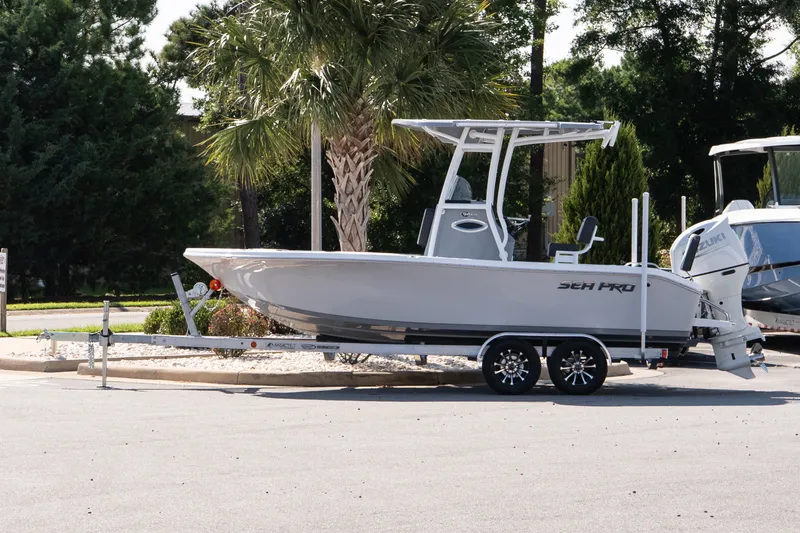 The Image of 2026 Sea Pro 202 Center Console boat on trailer, parked near palm trees. - 1