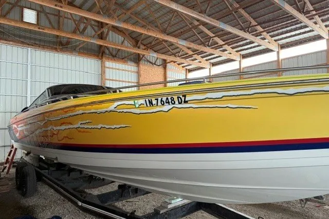 Slide: The Image of 2008 Formula 353 FASTech boat with vibrant yellow and red design in a storage facility. - 30