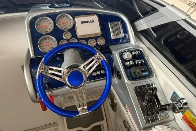 Slide: The Image of 2008 Formula 353 FASTech boat dashboard with blue steering wheel and control panel. - 13