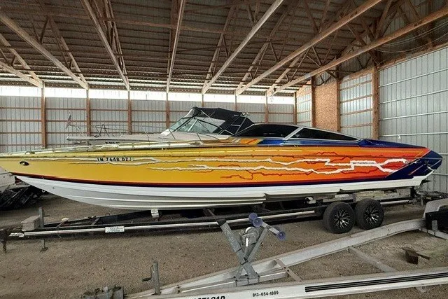The Image of 2008 Formula 353 FASTech speedboat with vibrant custom paint, stored indoors on a trailer. - 0