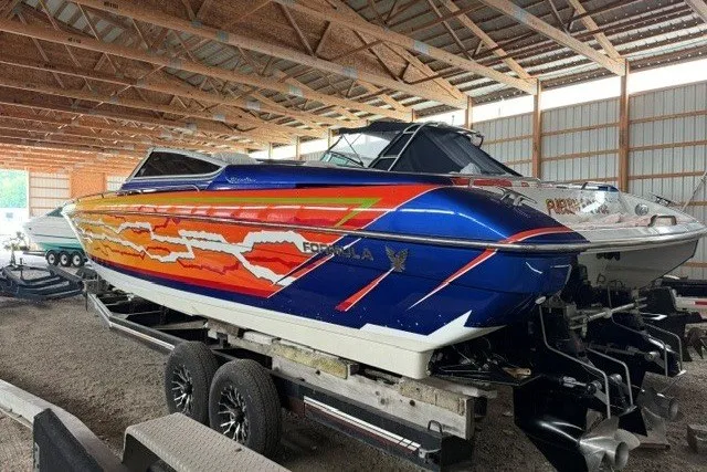 Slide: The Image of 2008 Formula 353 FASTech speedboat with vibrant graphics, stored indoors on a trailer. - 29