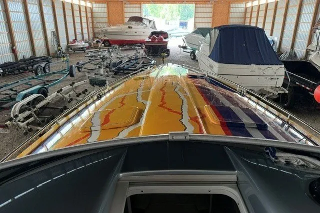 Slide: The Image of 2008 Formula 353 FASTech boat with vibrant graphics in a storage facility. - 33