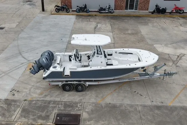Slide: The Image of 2026 Tidewater 256 CC Adventure boat on trailer in parking lot. - 2