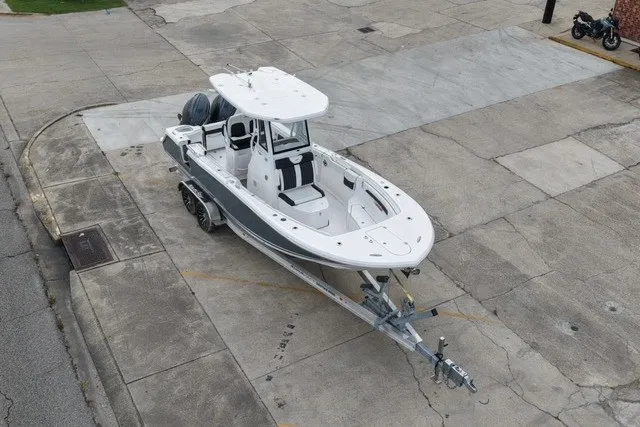 Slide: The Image of 2026 Tidewater 256 CC Adventure boat on trailer, parked on concrete surface. - 6