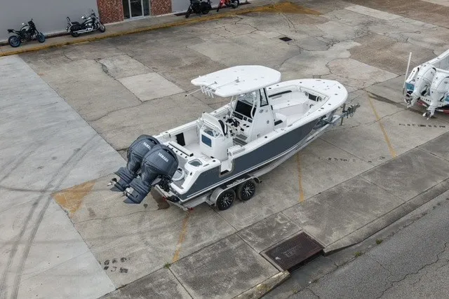 Slide: The Image of 2026 Tidewater 256 CC Adventure boat with dual engines on a trailer in a parking lot. - 4