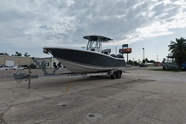 Slide: The Image of 2026 Tidewater 256 CC Adventure boat on trailer under cloudy sky. - 7