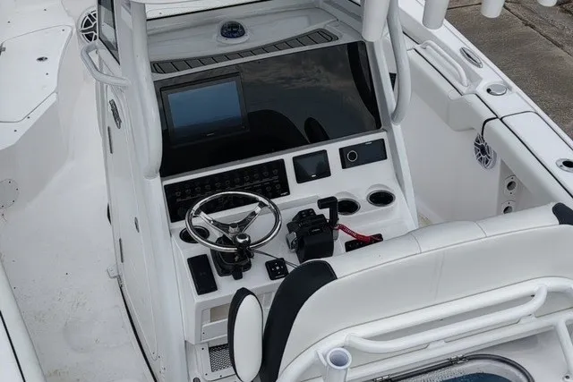 Slide: The Image of 2026 Tidewater 256 CC Adventure boat cockpit with steering wheel and control panel. - 9